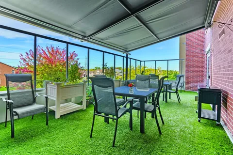 Covered patio with tables, chairs and flower planters
