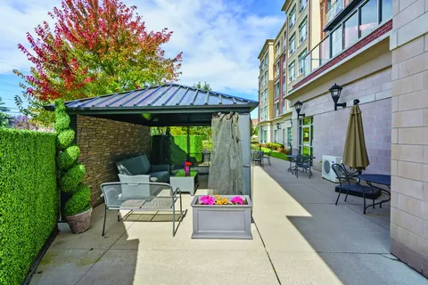Patio with chairs, flower planters and a sheltered sitting area