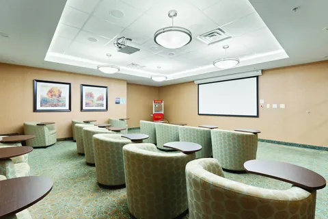 Rows of armchairs facing a blank projection screen