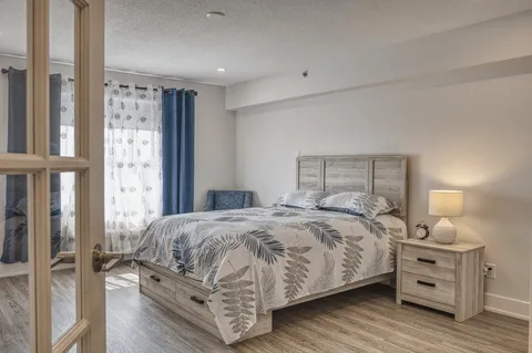 Bedroom with a bed beside glass doors and a window.