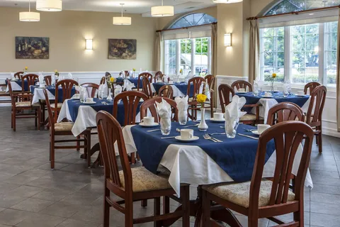 Dining room with set tables and large windows.
