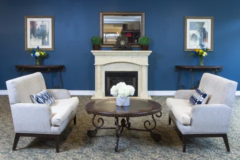 Lounge seating around a fireplace against a blue feature wall.