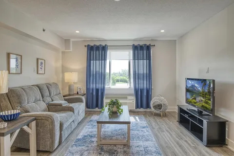Suite living area with a sofa, armchair and window.