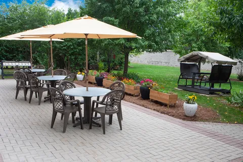 Garden patio with tables, umbrellas and raised planting beds.