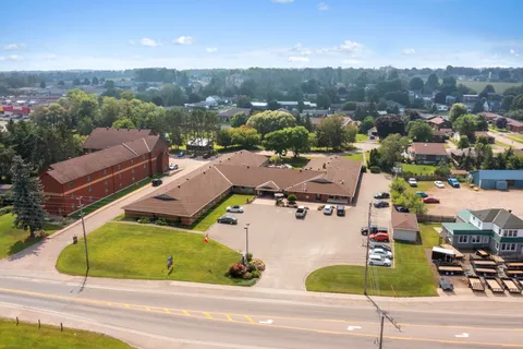 Aerial view of the residence and its parking area beside the street.