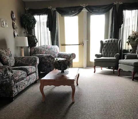 Shared lounge with patterned armchairs, a sofa and a coffee table.