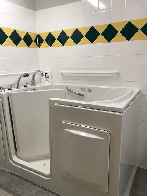 Bathing room with a walk-in tub and tiled walls.