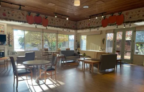 Room with tables, chairs and wide windows overlooking the courtyard