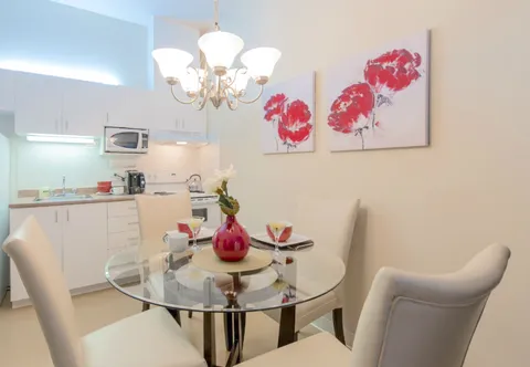 Apartment dining area with a round glass table.