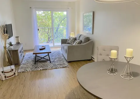 Apartment sitting area with a sofa and small tables.