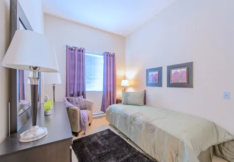 Bedroom with a single bed and an armchair.
