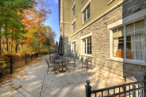 Patio tables beside the residence and autumn trees