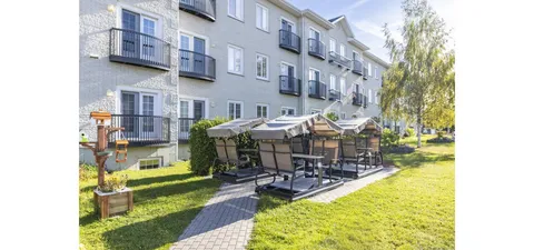 Covered swing seats on a paved garden path beside the residence