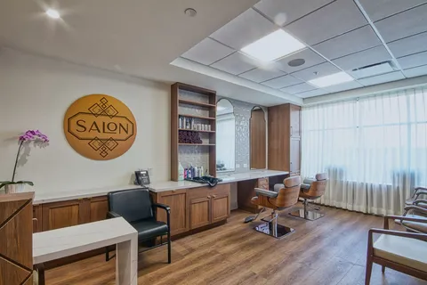 Salon with styling chairs, a mirror and window.
