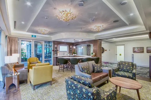 Lounge with patterned armchairs, sofas and pendant lights.