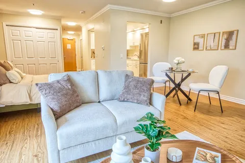 Studio suite with a sofa, bed and small dining table.