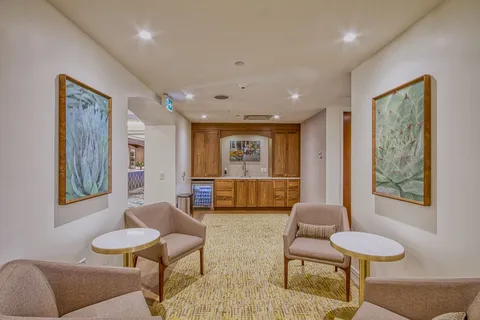 Hallway seating with two armchairs and wall artwork.
