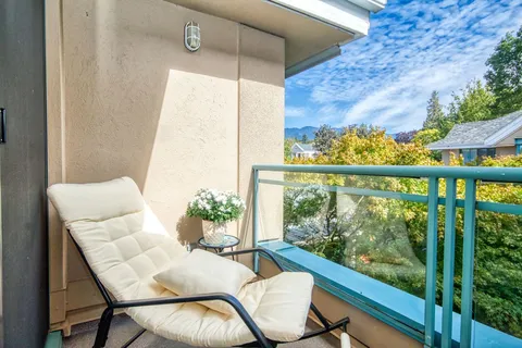 Balcony with a reclining chair and view of nearby rooftops.