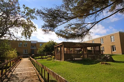 Rear of the residence beside a pergola and lawn