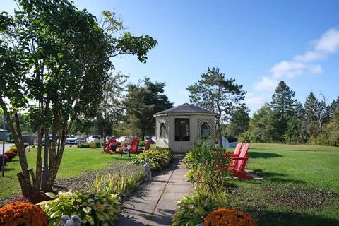 Garden path leading to a gazebo with Adirondack chairs