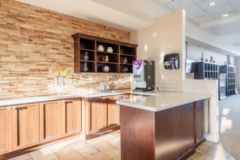 Counter with a coffee machine, sink and wooden cabinets