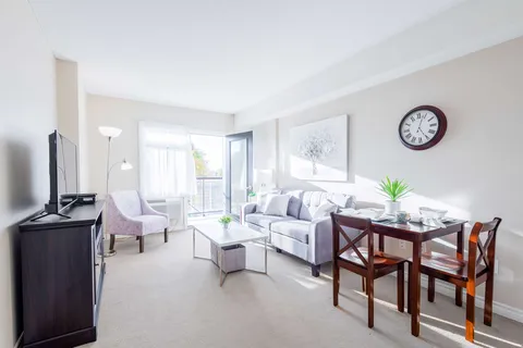 Sofa and dining table beside a blank television and balcony door