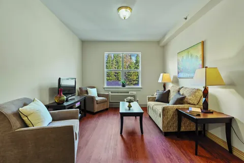 Sitting room with a sofa, armchairs, coffee table and window