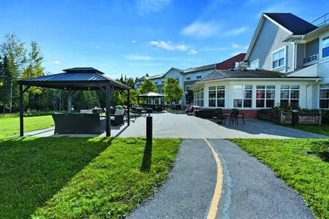 Paved garden path beside a gazebo, lawns and outdoor tables