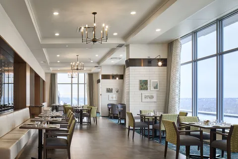 Dining room with tables beside floor-to-ceiling windows