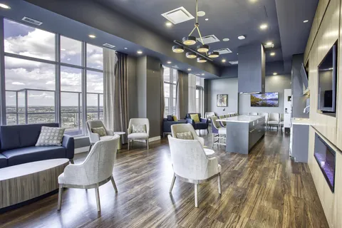 Lounge with a fireplace, armchairs and floor-to-ceiling windows