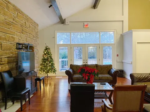 Lounge with armchairs, a brick wall and doors to the garden.