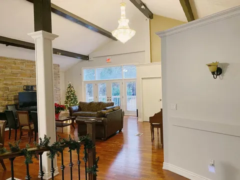 Shared lounge and dining area with wood ceiling beams.