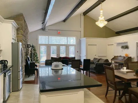 Shared kitchen with counters adjoining a dining and lounge area.