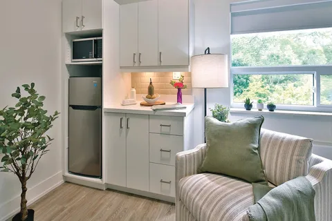Suite kitchenette beside an armchair and window