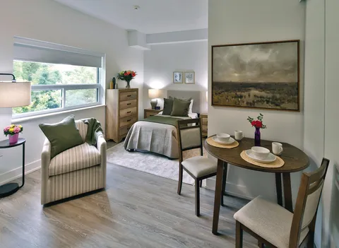 Studio suite with a bed, armchair and dining table