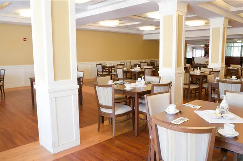 Dining room with set tables, wooden chairs and large windows