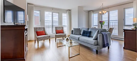 Living area with a grey sofa, two armchairs and balcony doors