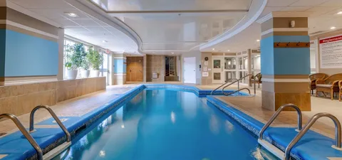 Indoor swimming pool with handrails and curved ceiling panels