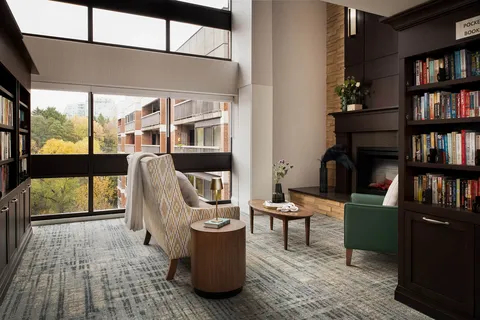 Library seating beside bookshelves and large windows