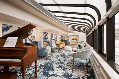 Conservatory lounge with a grand piano and glazed roof