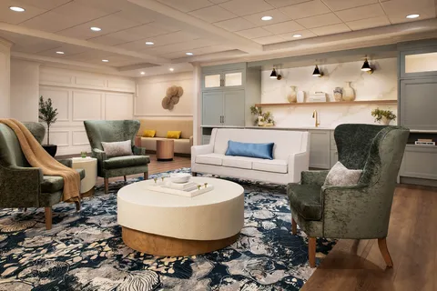 Lounge with armchairs, a sofa and built-in display shelves