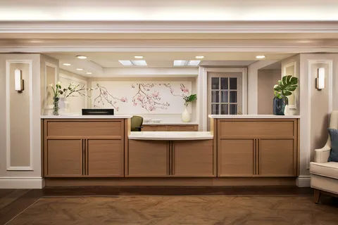 Reception desk with wooden cabinetry and a floral wall panel