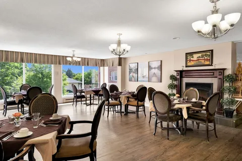 Dining room with set tables, fireplace and windows.