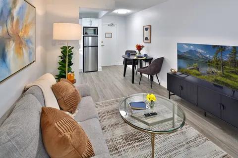 Suite living area beside a dining table and kitchenette.