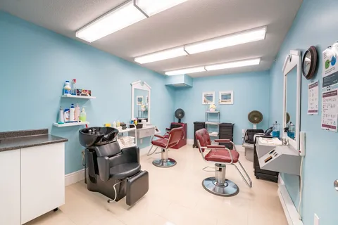 Salon with styling chairs, wash basins and mirrors.