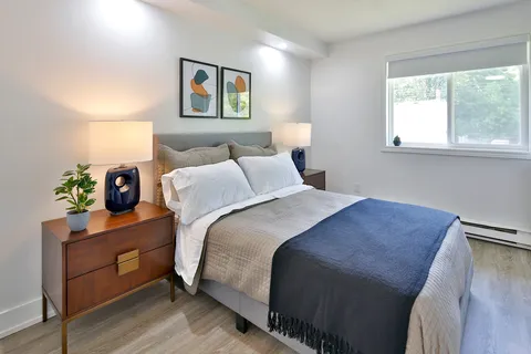 Bedroom with a bed, nightstand and window.