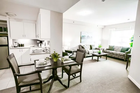Suite with a kitchen, dining table, sofas and large windows