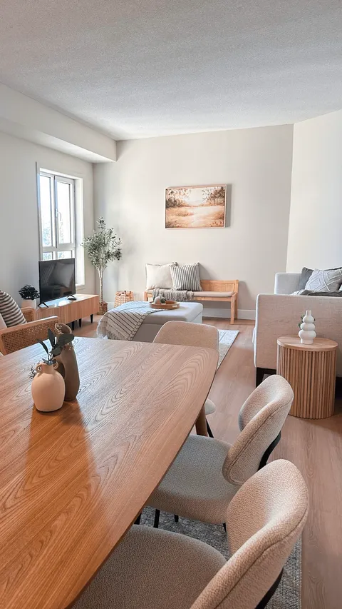 Suite dining table and upholstered chairs adjoining a sitting area.