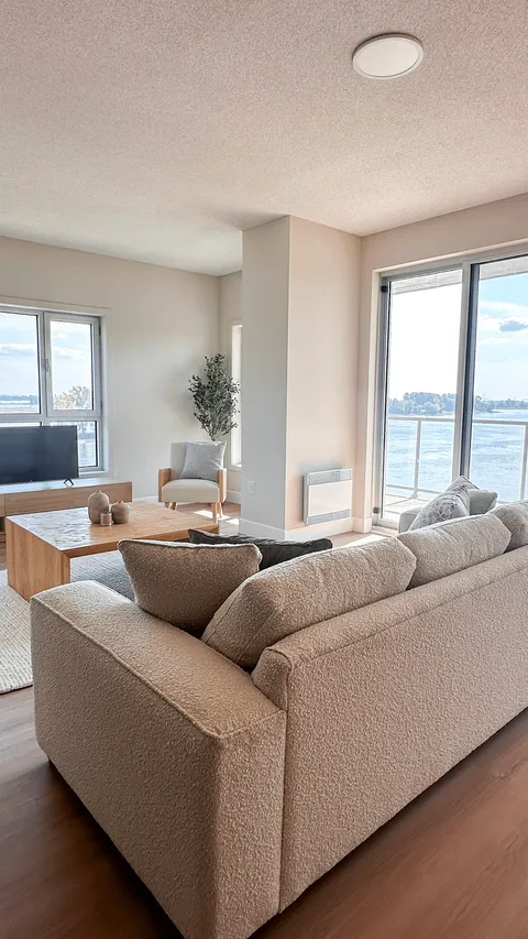 Suite living area with a grey sofa and corner windows.