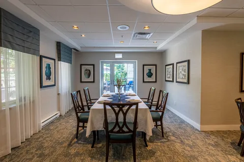 Dining room with a long table, framed vase prints and patio doors